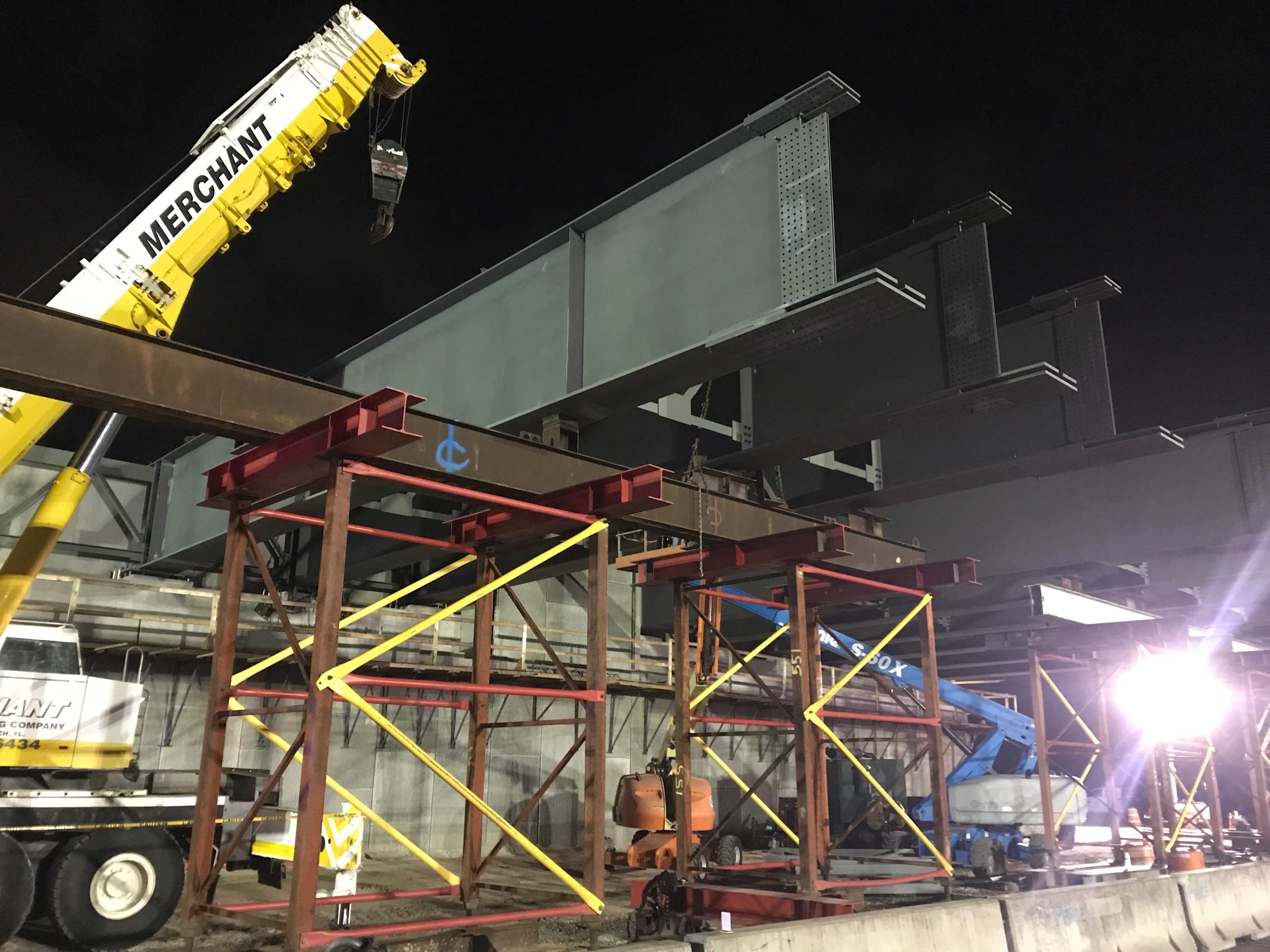 Steel girders set on temporary jacking towers at night